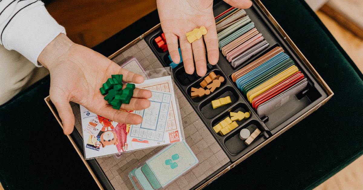 Componentes de un juego de mesa sobre una mesa de madera con fichas y cartas
