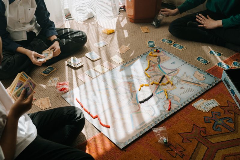 Componentes de un juego de mesa sobre una mesa de madera con fichas y cartas